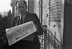Man reading a copy of the Yiddish-language newspaper "Forverts". 1946.