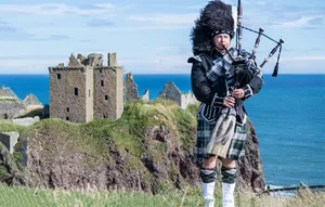 Scottish icons--a castle, bagpipes and a piper in tartan